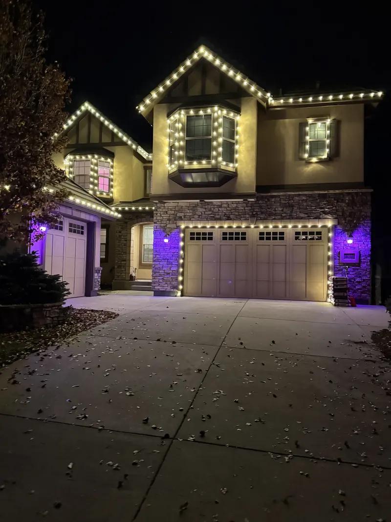 Tudor-style home outlined in warm white lights